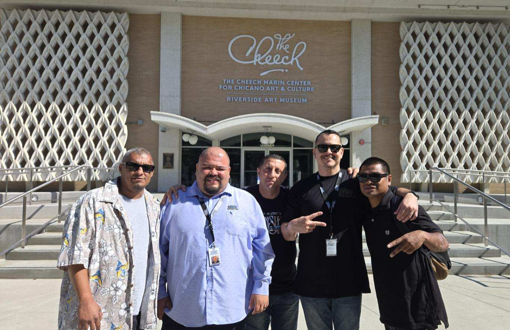 Group Visit to The Cheech Marin Center Five men smiling and posing on the steps in front of The Cheech Marin Center for Chicano Art & Culture building.