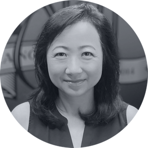 Professional Grayscale Portrait of Smiling Woman Smiling East Asian woman with dark, shoulder-length hair in a circular grayscale portrait, wearing a dark sleeveless top.