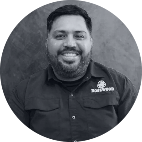 Friendly Man Smiling in Rosewood Company Shirt Smiling man with beard in black Rosewood shirt, circular profile picture, black and white.