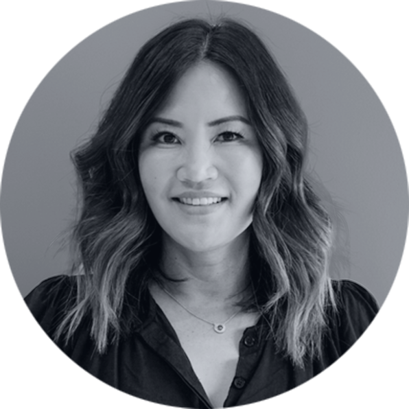 Professional Grayscale Headshot of a Smiling Woman Grayscale professional headshot of a smiling Asian woman with wavy hair, wearing a dark collared shirt and a delicate neckla…