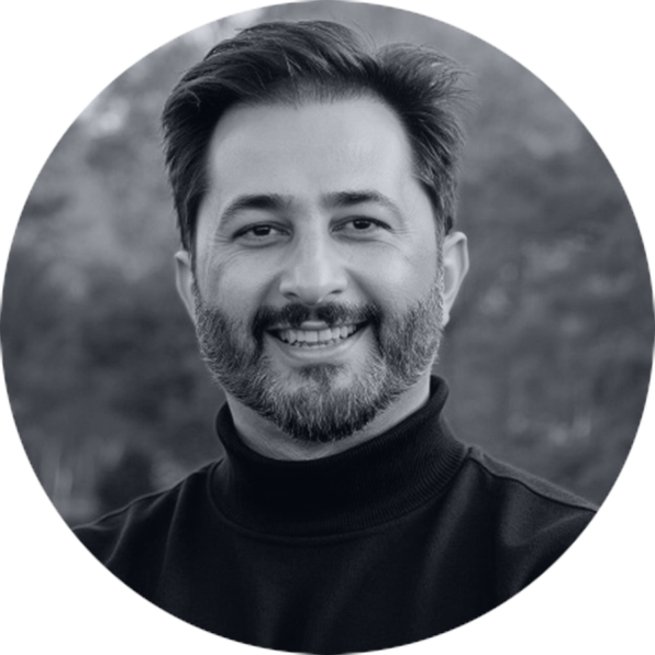 Confident Man Smiling in Black Turtleneck Portrait Smiling man with a beard and dark hair, wearing a black turtleneck, in a black and white circular portrait.