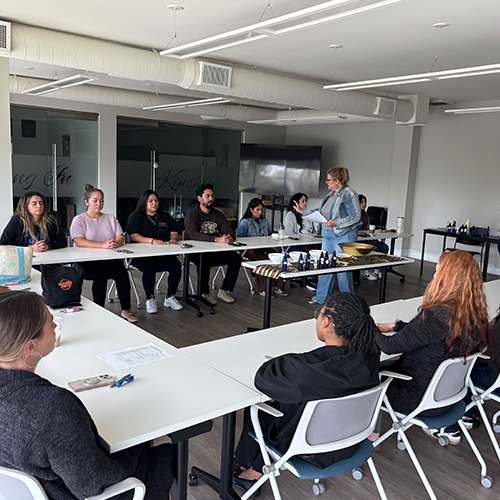 Healing Institute Workshop: Learning Natural Remedies An instructor leads a diverse group of participants in a hands-on healing workshop, demonstrating natural products and techn…
